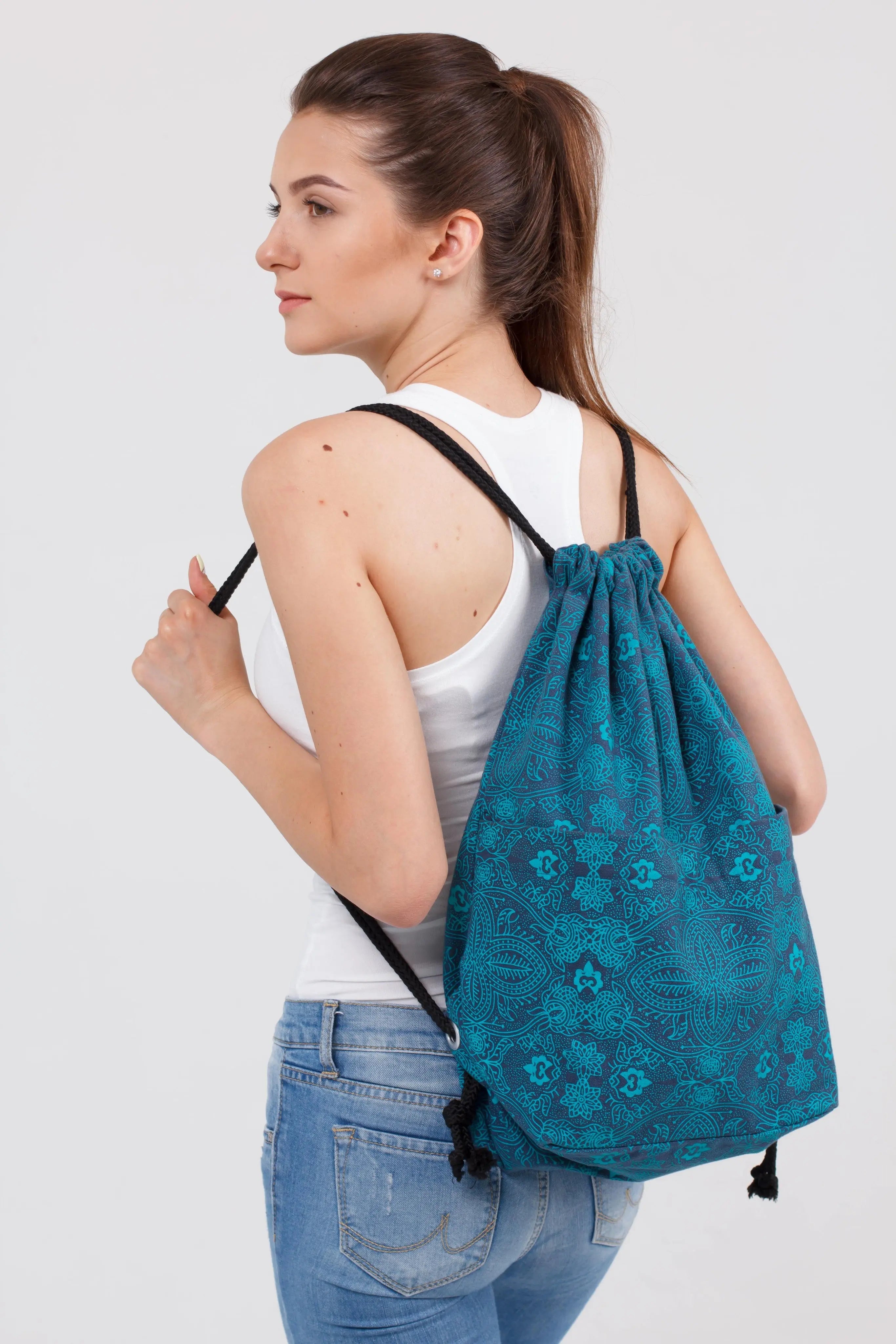 Frau trägt einen blauen Nijens Turnbeutel mit floralem Mandala-Muster und schwarzen Kordeln