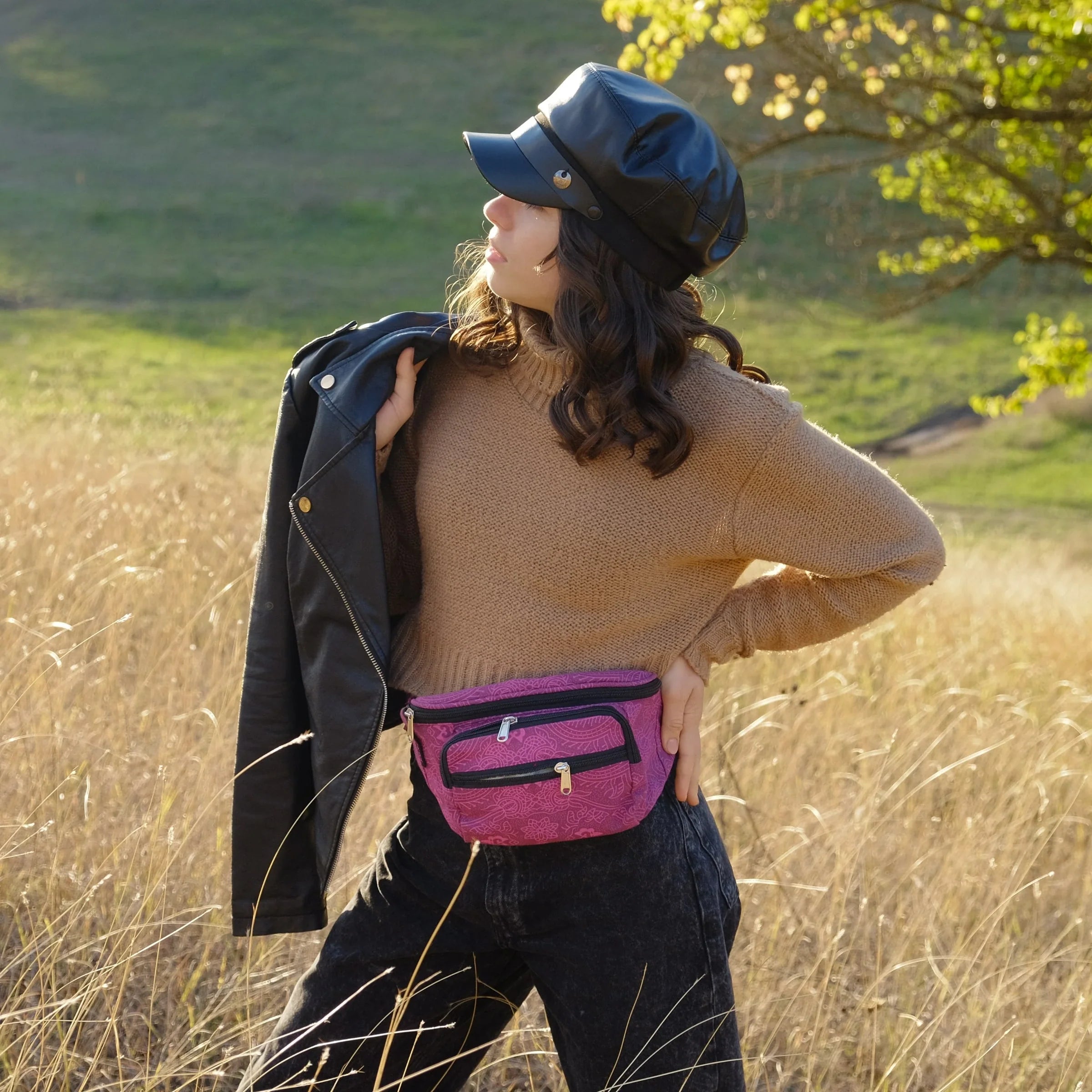 Model präsentiert kleine Bauchtasche aus Canvas Magenta in einem Feld.