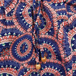 Hose aus Polyester, blau, rotem Muster mit elastischen Bund und Kordelzug am Saum . Zwei Holzperlen schmücken die Kordelenden.