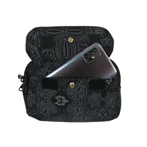 Beuteltsche aus Canvas schwarz mit floralem Muster. Die Tasche besitzt Reisverschlussfächer und ein Einsteckfach vorne, welches mit Druckknopf und Klett verschließbar ist.