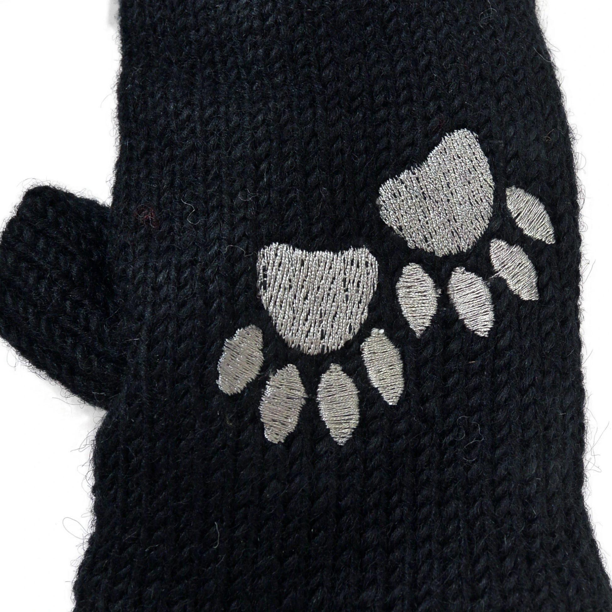 Nahaufnahme schwarzer Pulswärmer aus Schurwolle mit gesticktem Pfotenmotiv – wärmendes Winter-Accessoire mit Fleecefutter