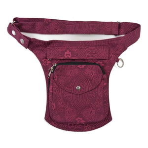 Gassi-Tasche, Bauchtasche aus robustem Baumwollstoff in Magenta mit floralen Ornamenten. Diese Gürteltasche besitzt zwei Reißverschlussfächer vorne sowie ein Einsteckfach, welches durch einen Überschlag und einen Druckknopf verschlossen wird. Auf der hinteren Seite befindet sich ein weiteres Reißverschlussfach. An der Seite des Taschengurtes befindet sich ein kleiner Metallring zum Anhängen kleiner Beuteltaschen.