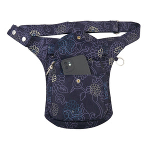 Gassi-Tasche, Bauchtasche aus robustem Baumwollstoff in Violett mit floralen Ornamenten. Diese Gürteltasche besitzt zwei Reißverschlussfächer vorne sowie ein Einsteckfach, welches durch einen Überschlag und einen Druckknopf verschlossen wird.