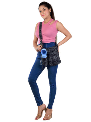 Frau trägt die Gassitasche mit schwarzem Blumenmuster, breitem Tragegurt, integriertem Kotbeutelspender und Flaschenhalter.