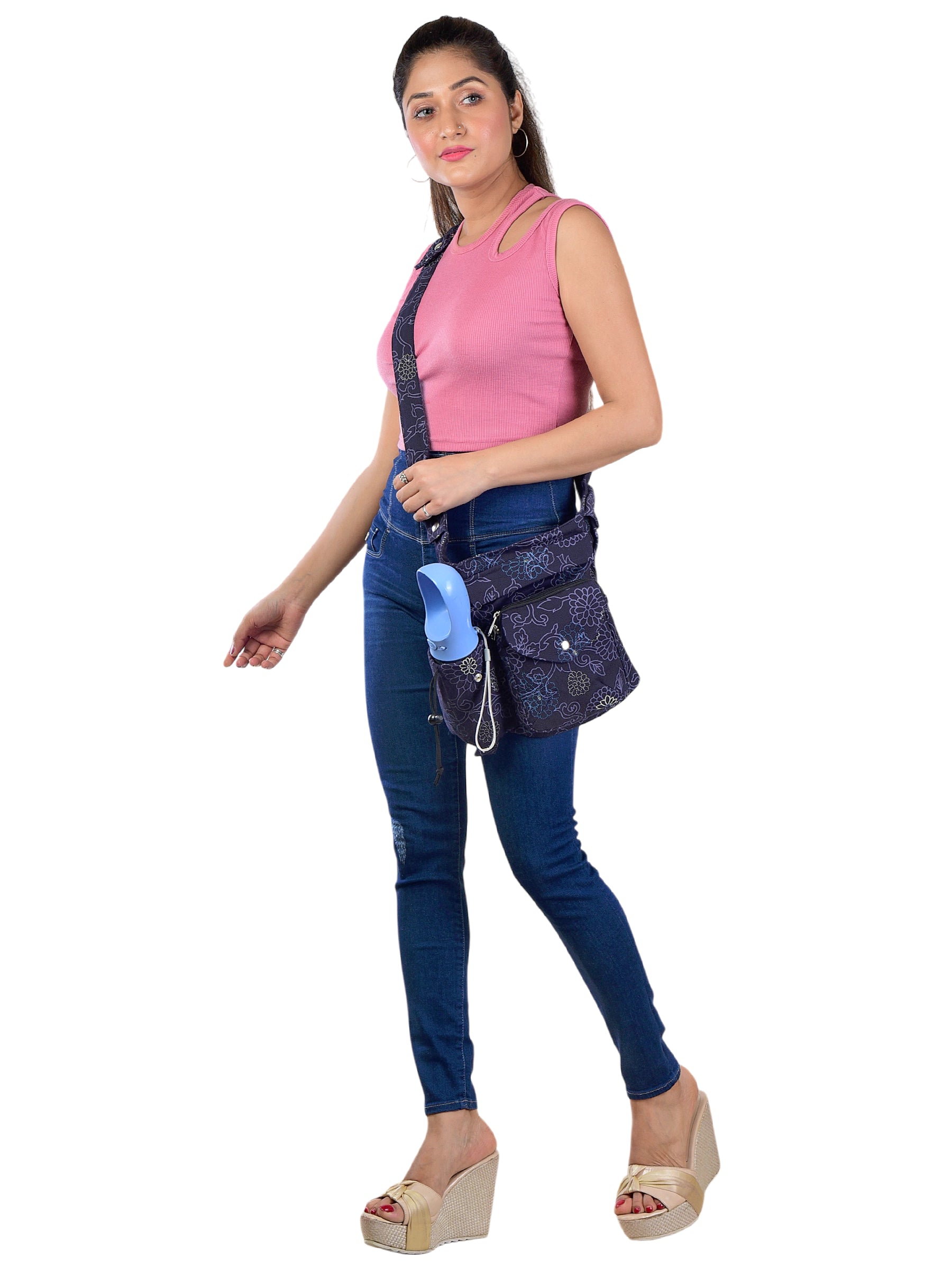 Frau präsentiert die Crossbody-Tasche mit floralem Design und breitem verstellbaren Gurt – ideal für Hundespaziergänge mit Trinkflasche und Kotbeutelspender