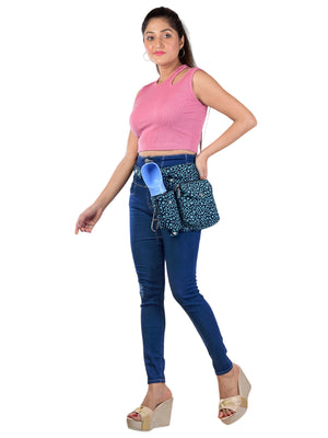 Frau präsentiert die Gassi-Tasche aus Canvas mit mintfarbenem Pfotenmuster – mit Flaschenhalter & Leckerlifach.