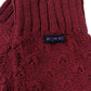 Detailaufnahme der bordeauxroten Woll-Beinstulpen mit Nijens Label