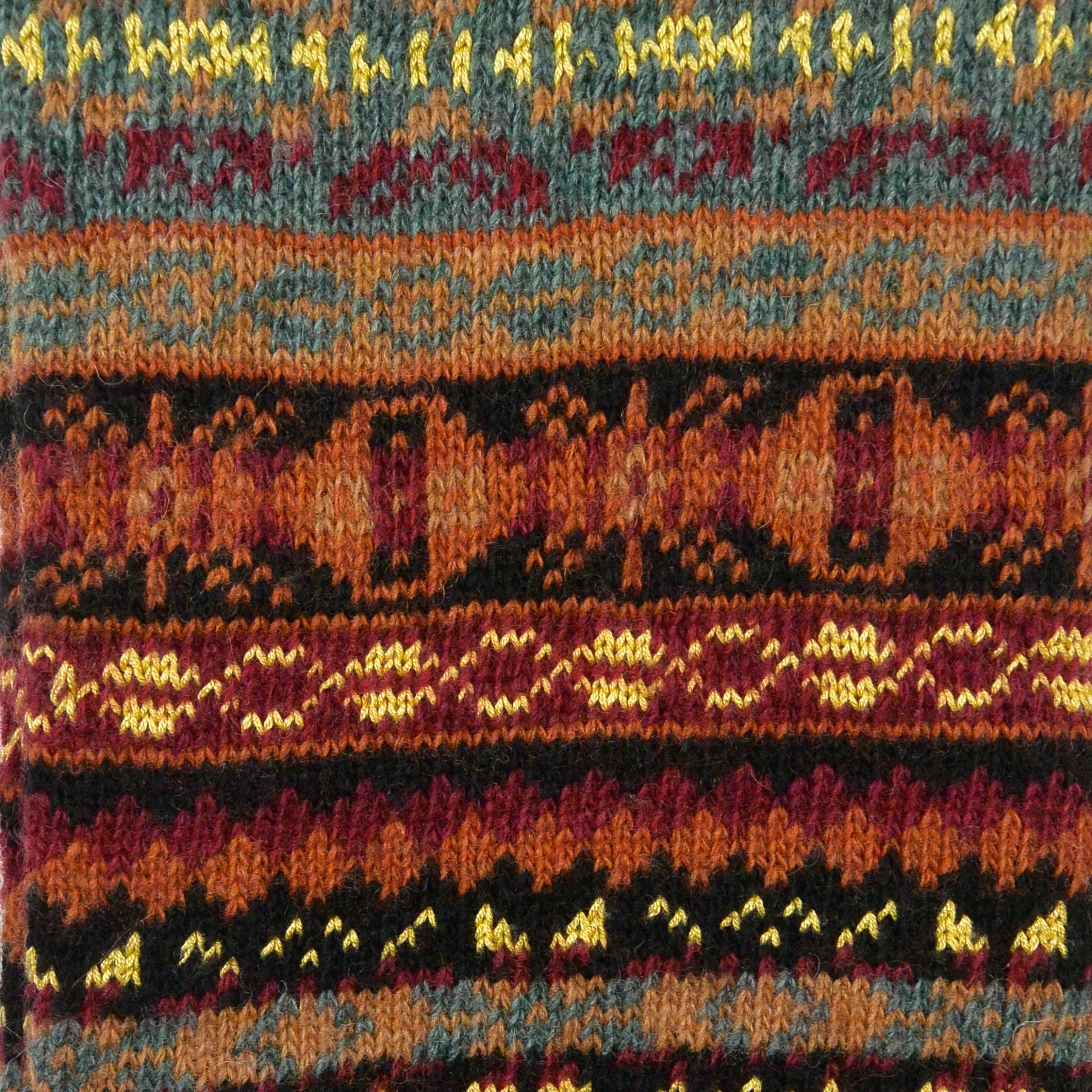 Detailaufnahme des Jacquard-Strickmusters der Beinstulpen Rosenheim in Schwarz, Gelb und Dunkelrot.