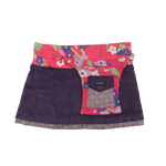 Wenderock aus Kordsamt Lila. Der Rockbund ist pink aus Baumwolle mit Blumen und durch zwei Druckknopfleiste größenverstellbar. An der Seite gibt es eine abnehmbare Stofftasche.