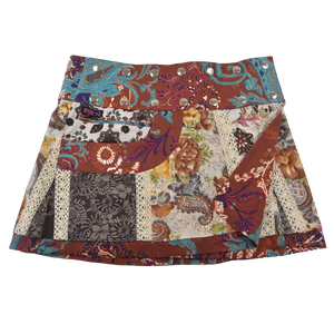 Sommerrock aus Baumwolle in buntem Mustermix und weißer Spitze. Umfang ist verstellbar mit doppelter Druckknopfleiste mit Seitentasche.