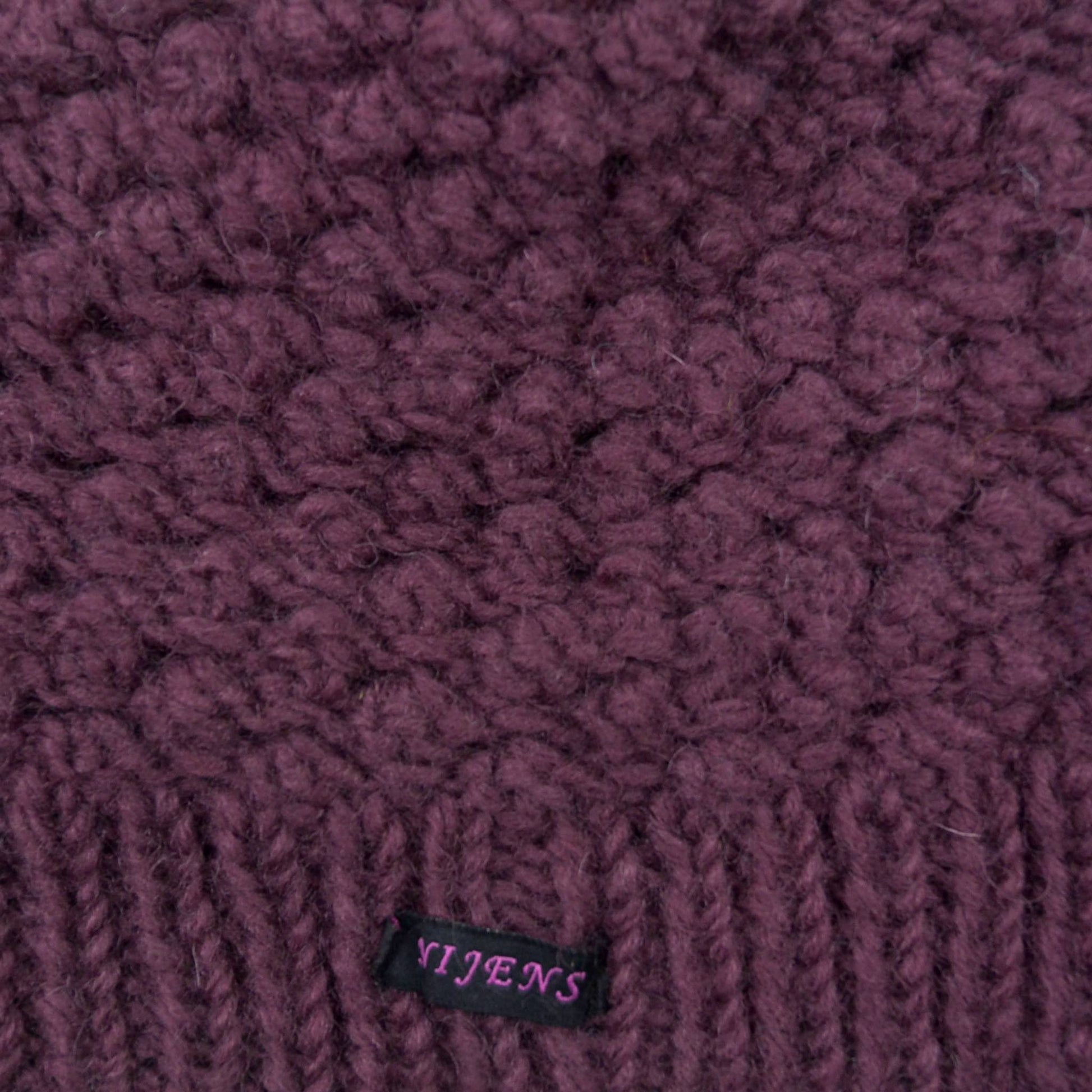 Materialausschnitt Kurze Beanie Mütze, Wollmütze, handgestrickt aus Schurwolle, Lila.