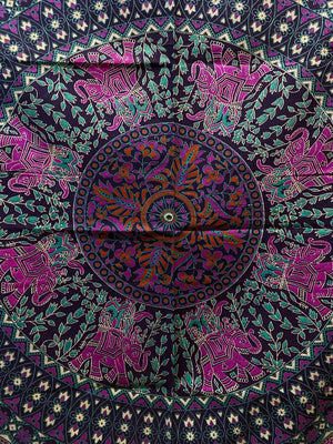 Detailaufnahme einer Mandala-Decke in Lila-Türkis mit floralen Elementen und Elefantenmotiven im Kreisdesign