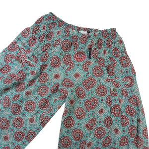 Detailansicht der türkis-roten Viskosehose mit elastischem Bund und Knopftaschen von Nijens.