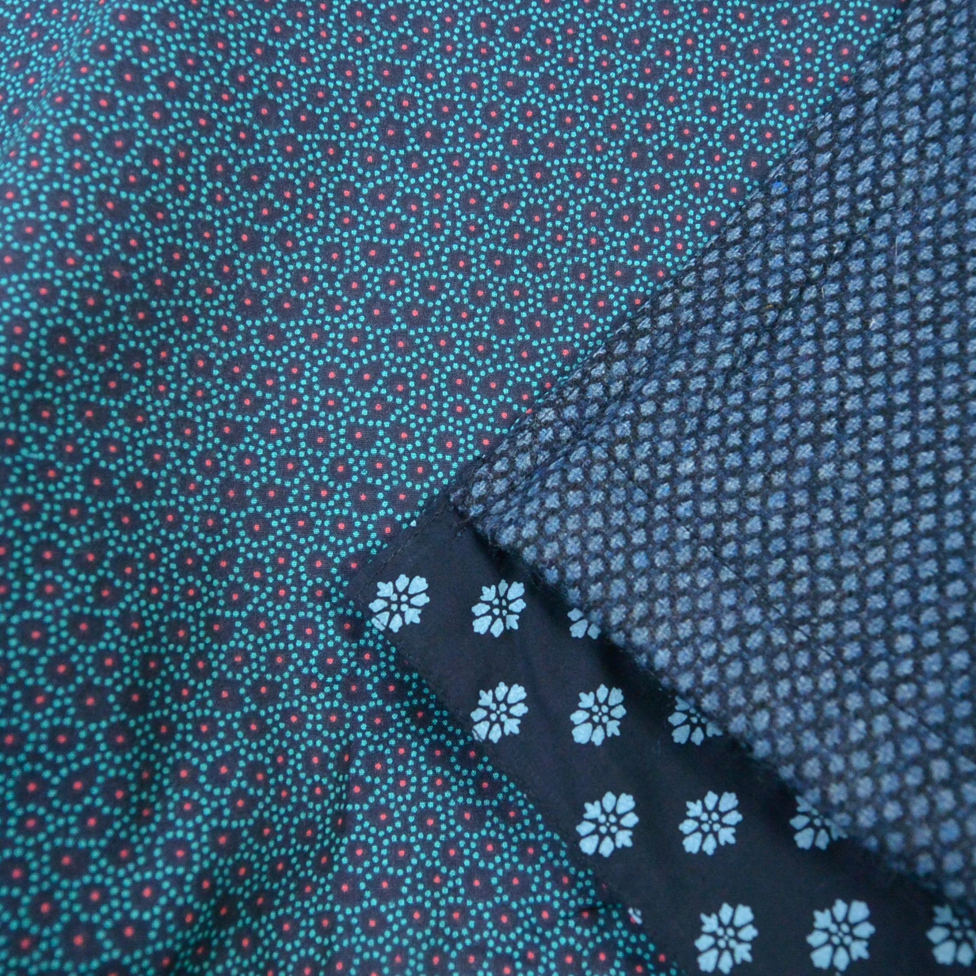 Detailaufnahme des Nijens Wenderocks: Blaue Tweedstruktur, gemusterte Innenseite und feine Stoffdetails der reversiblen Winterrock-Designs.