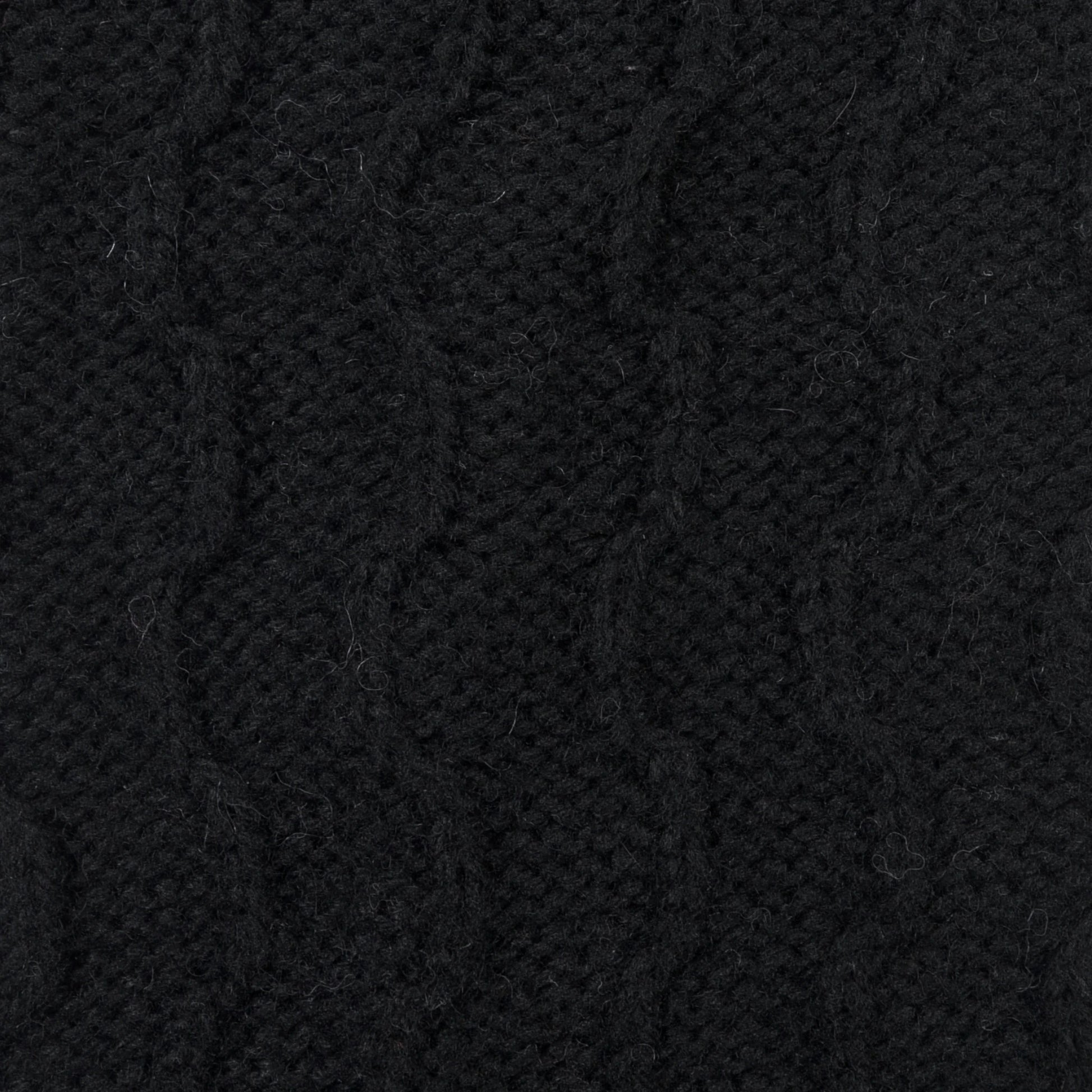 Detailaufnahme des Zopfmusters der Beinstulpen Lindau in Schwarz