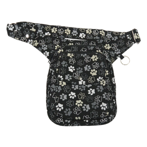 Gassi-Tasche, Hüfttasche aus Canvas Schwarz mit Hundepfoten Motiven. Zwei Reißverschlussfächer vorne und eines auf der Hinterseite. Ein aufgesetztes Einsteckfach mit Überlappung wird mit einem Druckknopf verschlossen. An der Seite gibt es einen Schlüßelring zum Anbringen von kleinen Beuteltaschen.