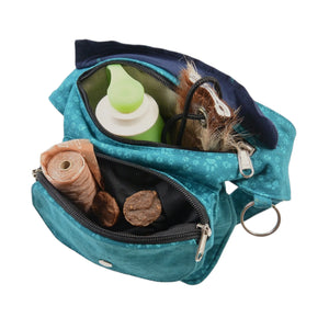 Türkisblaue Bauchtasche Hannover von Nijens mit aufgesetztem Leckerli-Fach, geöffnet und mit Hundekeksen gefüllt, mit Trinkflasche und Wurf-Dummy.