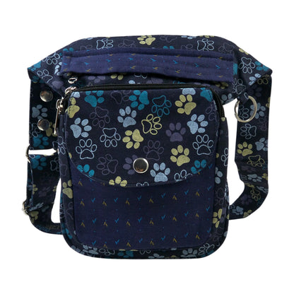 Nijens Gassitasche Hannover aus Canvas-Baumwolle in Blau-Lila mit Pfoten-Muster in Gelb, Frontansicht mit Druckknopfklappe, Reißverschlussfach und verstellbarem Gurt.