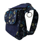 Nijens Gassitasche Hannover aus Canvas-Baumwolle in Blau-Lila mit Pfoten-Muster in Gelb, Seitenansicht mit Druckknopfklappe, Reißverschlussfach und verstellbarem Gurt.