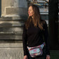 Frau trägt die bunte Mandala-Hüfttasche von Nijens als Crossbody-Bag über der Schulter, im urbanen Lifestyle.