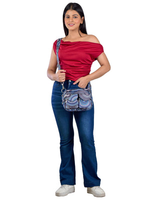 Model präsentiert eine bunte, wasserabweisenden Gassitasche, Mandala-Design in Blautönen mit der Tragevariante "Crossbodybag". Diese Tasche besitzt vier praktische Fächer zum Verstauen von Handy, Schlüssel und anderen Dingen sowie zwei aufgesetzte Leckerli-Taschen – ideal für Hundespaziergänge und Training.– Modell 'Berlin 71080' von Nijens.