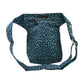 Nijens Gassitasche Hannover aus Canvas-Baumwolle in Teal mit Pfoten-Muster, Rückansicht mit Druckknopfklappe, Reißverschlussfach und verstellbarem Gurt.