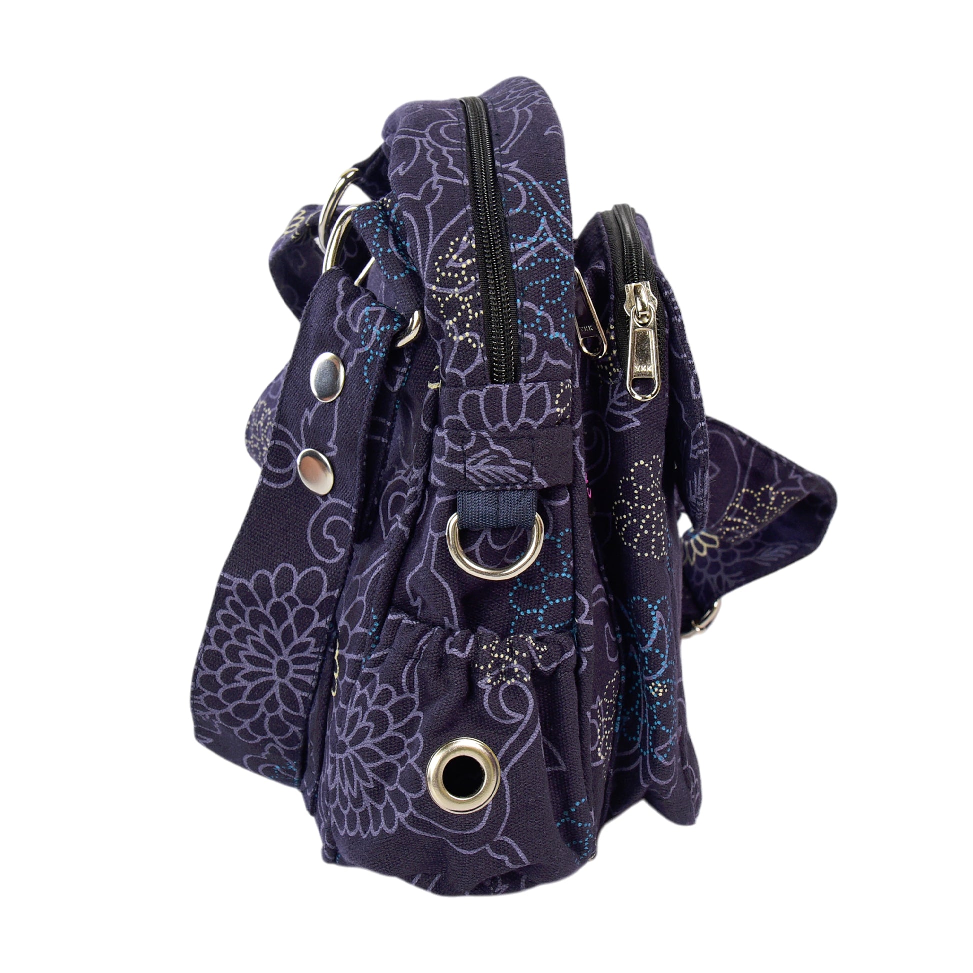Seitenansicht der Tasche mit silbernen Ringen, Reißverschlüssen und Blumenmuster – funktional und dekorativ.
