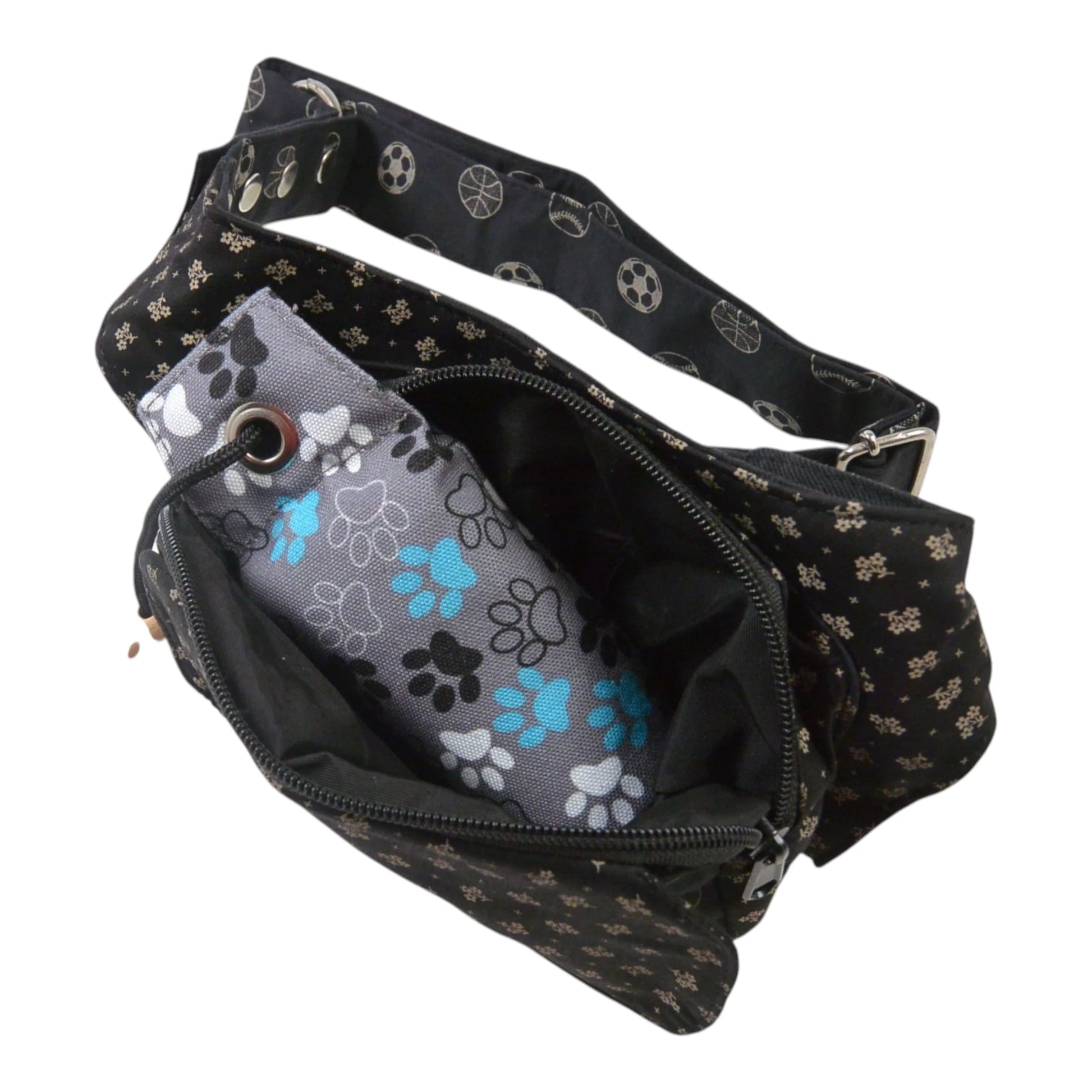 Hundetasche aus schwarzem Stoff mit Ball-Print, geöffnete Innenansicht mit Leckerli-Fach und Wurf-Dummy