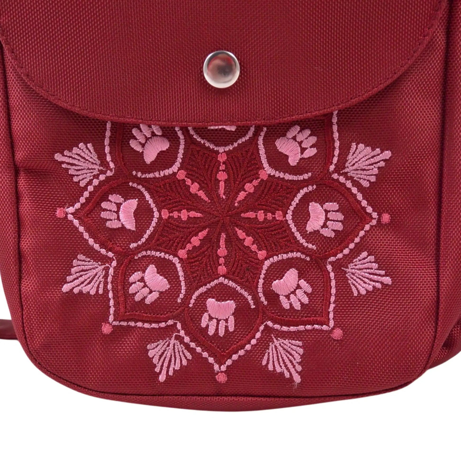Detailaufnahme der Mandala-Stickerei mit Pfotenmotiv auf roter wasserabweisender Gassitasche aus Polyester, stilvolles Design für unterwegs.
