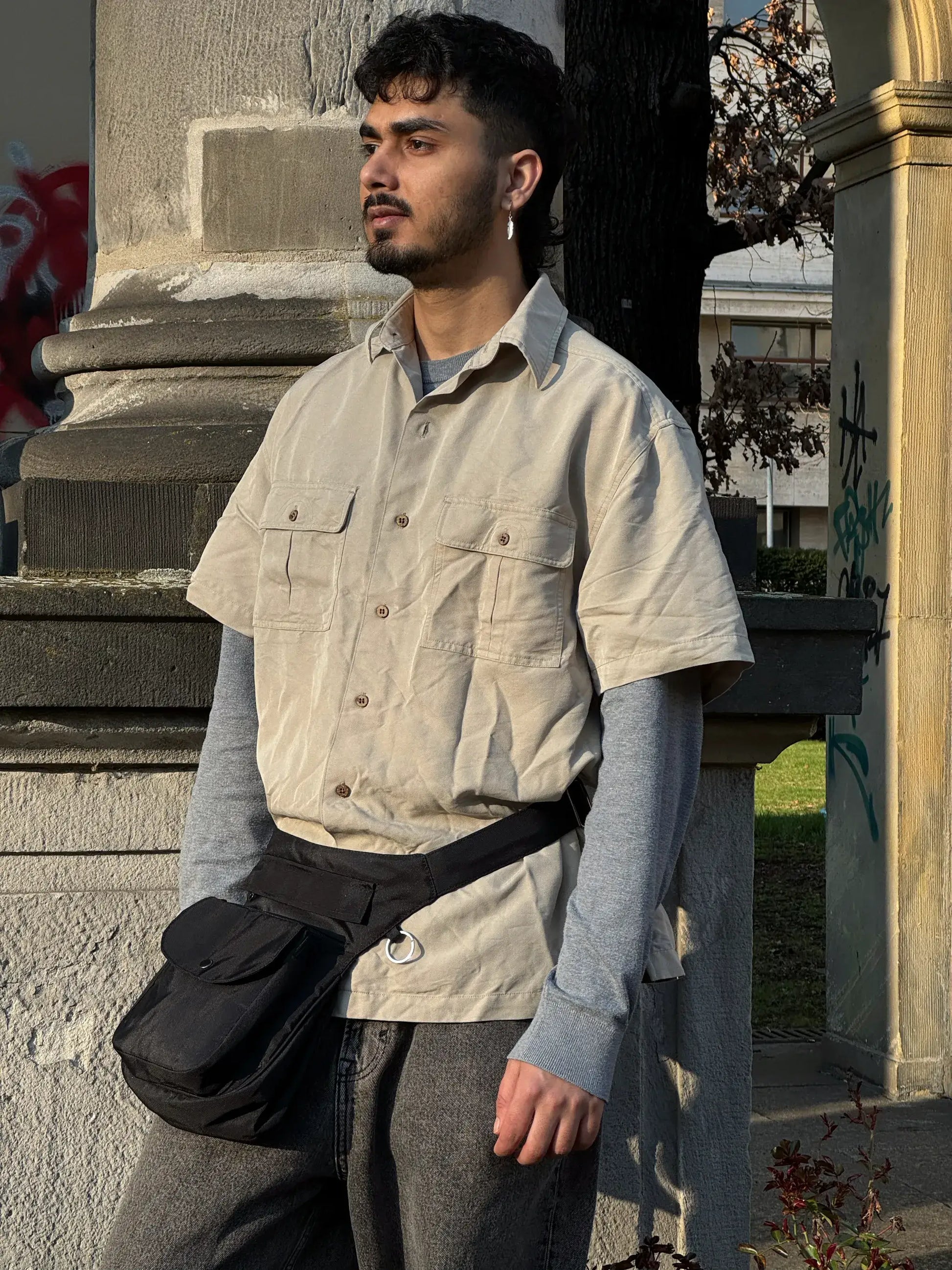 Model trägt schwarze wasserabweisende Gassi-Tasche von Nijens als Hüfttasche im urbanen Alltag