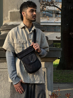 Schwarze Nijens Gassi-Tasche wasserabweisend als Crossbody getragen von Model im Stadtpark