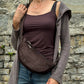 Model präsentiert Schokobraune Cord-Crossbody-Tasche „Rishikesh“ von Nijens in Frontalansicht, mit Reißverschluss und verstellbarem Gurt