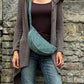 Model präsentiert Crossbodybag „Rishikesh“ aus Cord Salbei von Nijens in Frontalansicht, mit zwei Reißverschlussfächern und verstellbarem Schultergurt