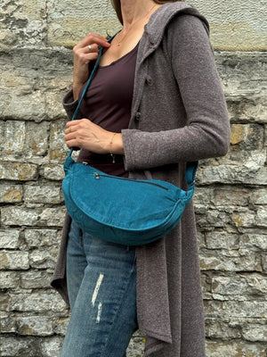 Model trägt Petrolfarbene Crossbodybag „Rishikesh“ aus Cord von Nijens in Frontalansicht, mit zwei Reißverschlussfächern und verstellbarem Schultergurt