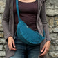 Model präsentiert petrolfarbene Crossbodybag „Rishikesh“ aus Cord von Nijens in Frontalansicht