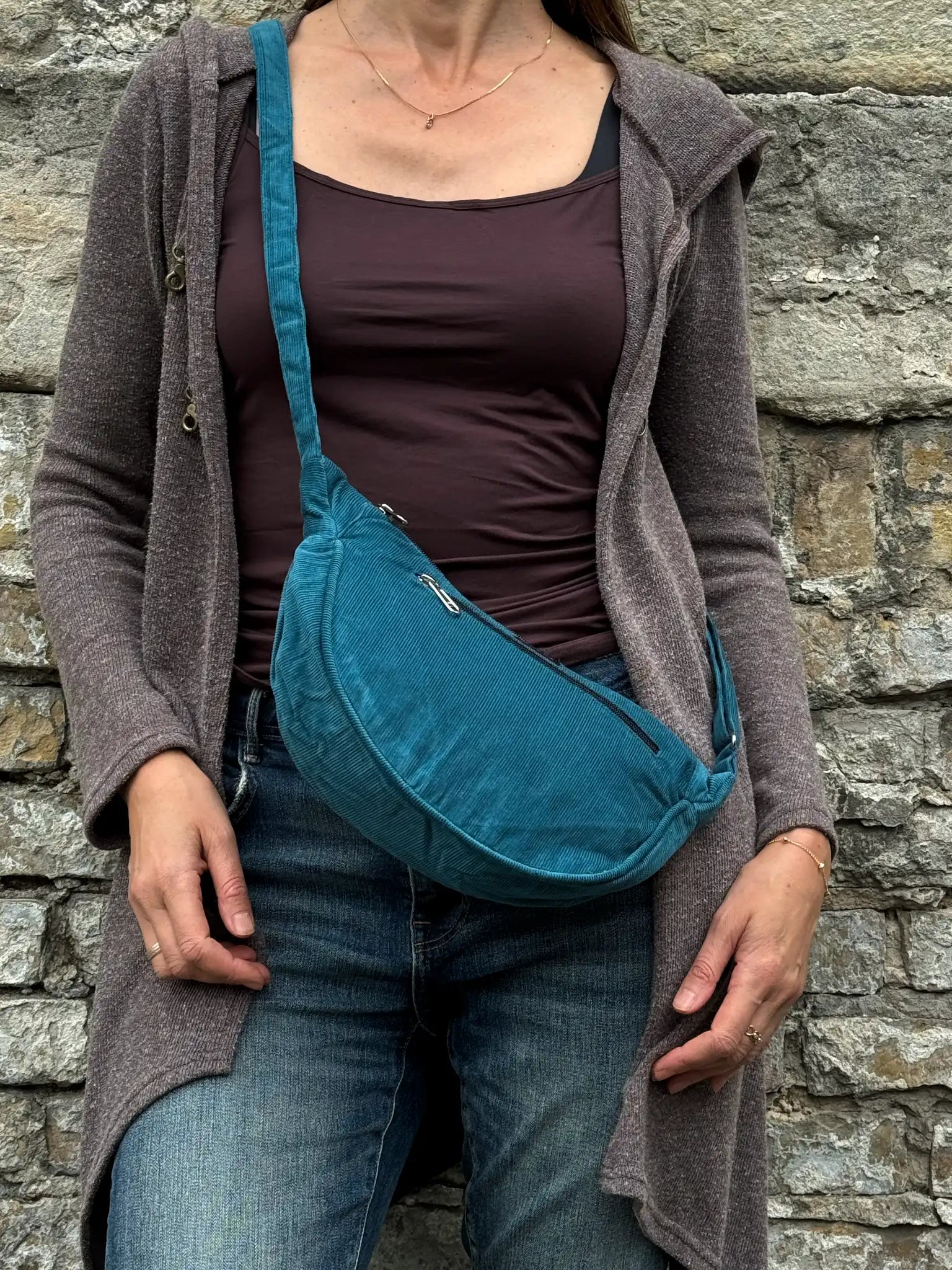Model präsentiert petrolfarbene Crossbodybag „Rishikesh“ aus Cord von Nijens in Frontalansicht