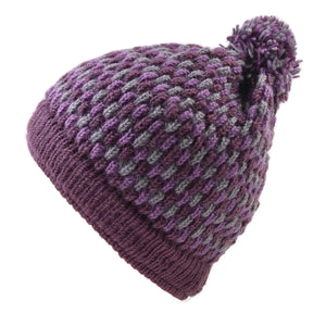 Seitenansicht: Bommelmütze aus Schurwolle in Lila-Grau-Tönen.