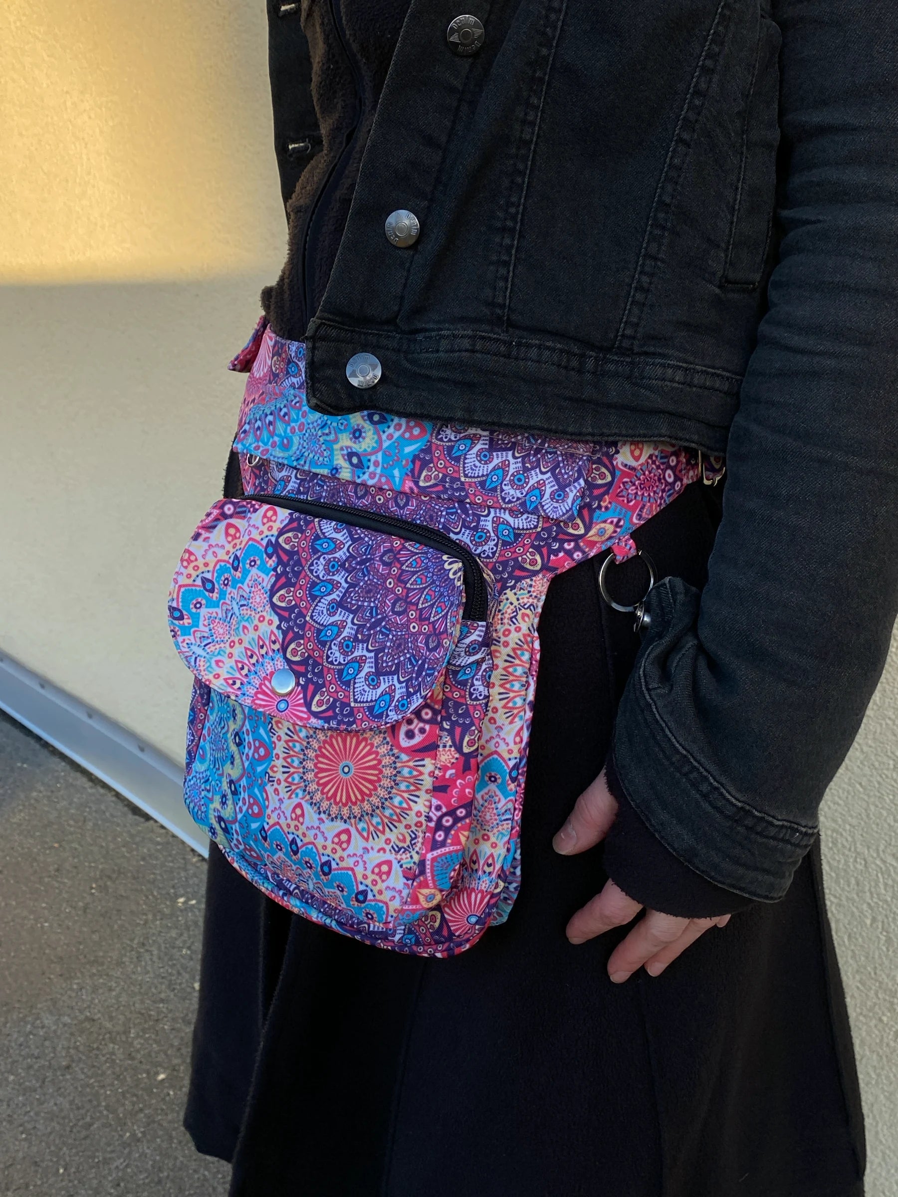 Model präsentiert Gassi-Tasche, Bauchtasche und Gürteltasche aus Polyester Bunt mit Mandala Motiven mit der Tragevariante Hüfttasche.