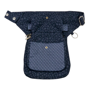 Gassi-Tasche aus Canvas- Stoff Violett mit kleinen Pfotenmotiven mit zwei Reißverschlussfächer vorne sowie einem Einsteckfach, welches durch einen Überschlag mit einem Druckknopf verschlossen wird.