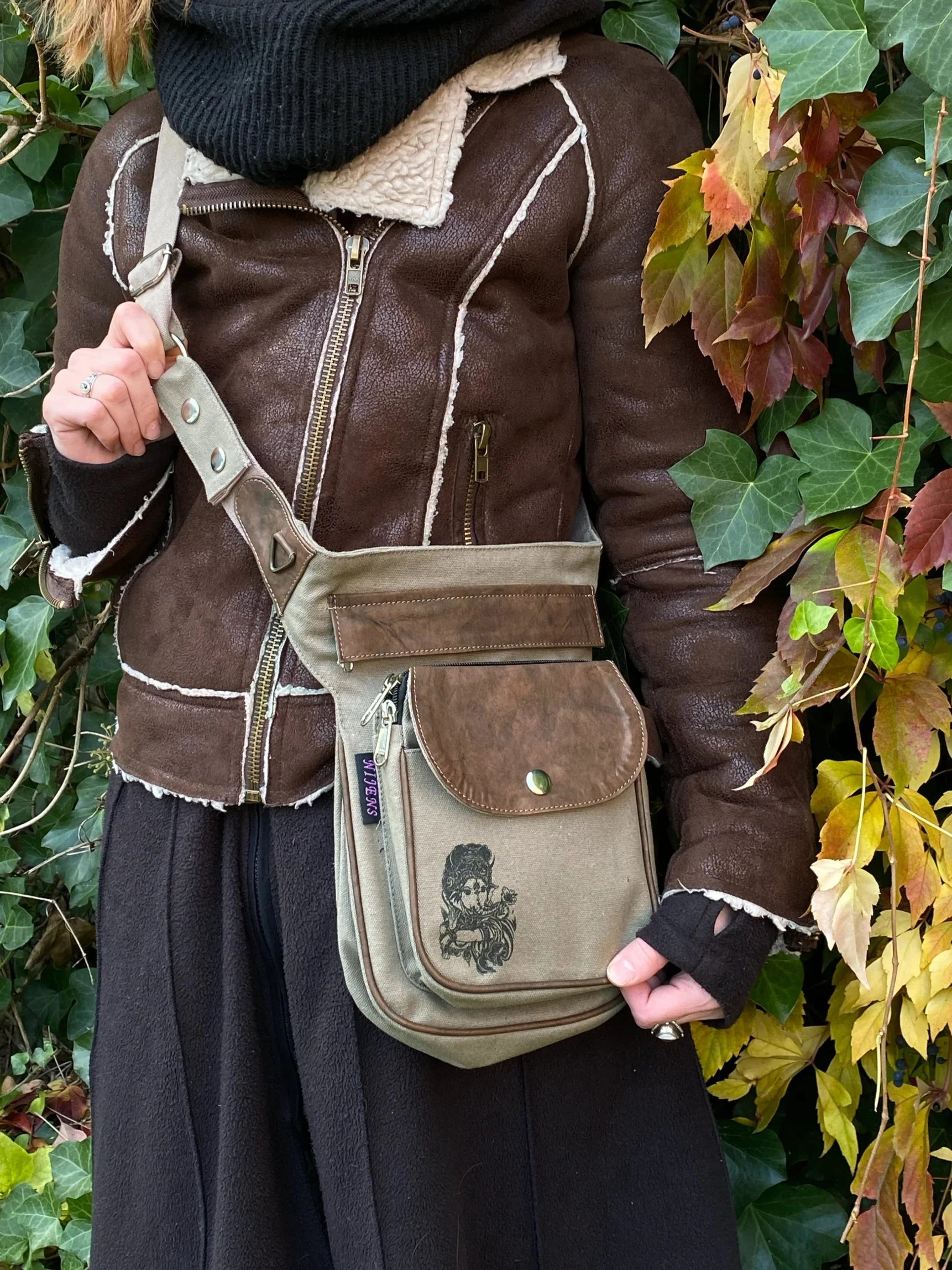 Model mit Gürteltasche, Gassi-Tasche in Canvas-Sand mit Ganesha-Aufdruck auf der Vorderseite. Variante als Umhängetasche.