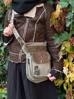 Model mit Gürteltasche, Gassi-Tasche in Canvas-Sand mit Ganesha-Aufdruck auf der Vorderseite. Variante als Umhängetasche.