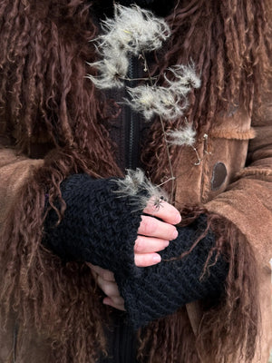 Nahaufnahme Hände: Model präsentiert Handstulpen mit Daumen aus schwarzer Schurwolle.