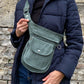Model präsentiert Bauchtasche, Gassi-Tasche aus Cord Salbeigrün als Umhängetasche über der Schulter.
