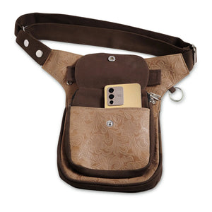 Hüfttasche, Gassi-Tasche aus Leder und Baumwoll-Canvas in Brauntönen, mit floraler Ornamentenprägung. Der Taschengurt ist größenverstellbar und das Einsteckfach vorne bietet Platz fürs Handy und wird durch einen Überschlag mit Klett und Druckknopf verschlossen.
