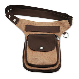 Hüfttasche, Gassi-Tasche aus Leder und Baumwoll-Canvas in Brauntönen, mit floraler Ornamentenprägung. Diese Hüfttasche hat eine Reißverschlussfach auf der hinteren Seite und zwei Reißverschlussfächer vorne sowie ein Einsteckfach, welches durch einen Überschlag mit einem Magnetknopf verschlossen wird. An der Seite des Taschengurtes befindet sich ein kleiner Metallring  in Form eines Dreiecks zum Anhängen kleiner Beuteltaschen.