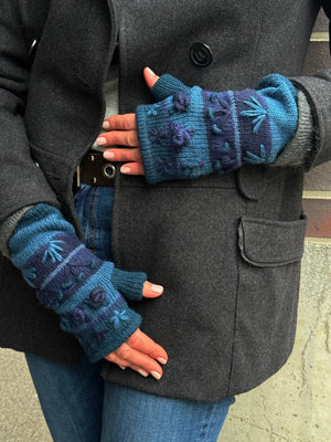 Nahaufnahme Hände: Model präsentiert Handstulpen HEIDRA Set C-16 gestreift aus Schurwolle in Blautönen und Woll-Stickereien.