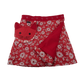 Wenderock XL für Kinder aus Baumwolle, Rot, mit Blumenmuster und Druckknopfleiste.