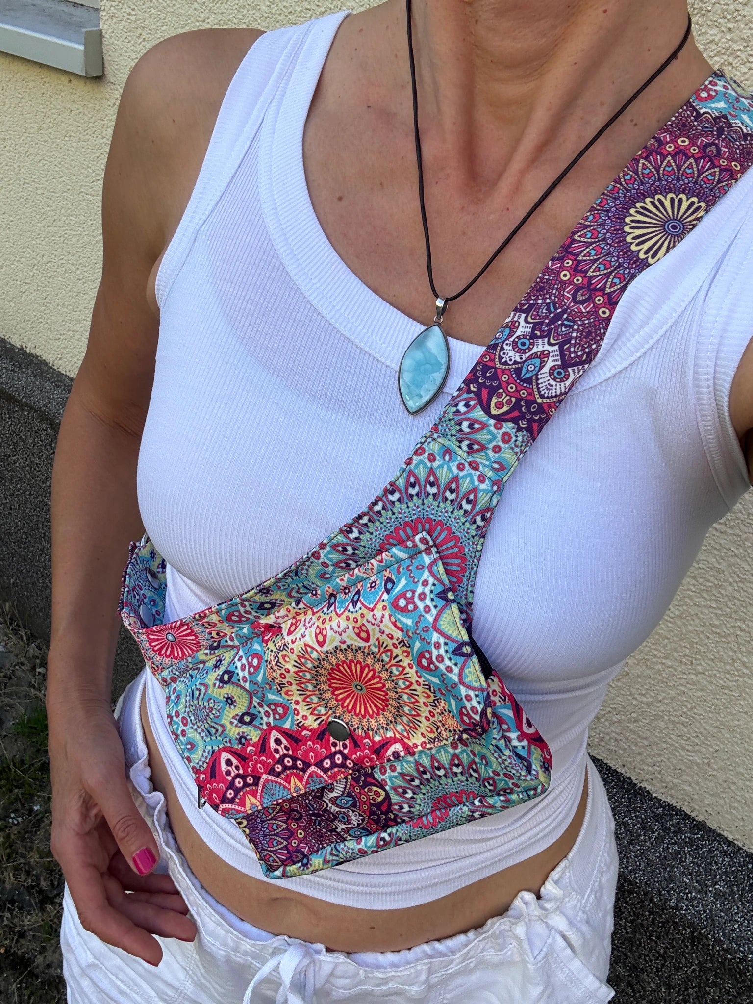 Frau trägt bunte Crossbodytasche mit Mandala-Print in Rosa-Türkis.