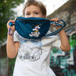 Der Junge hält eine Tasche von Nijens in der Hand. Crossbody Tasche mit Stickmotiv "Let´s SURF".