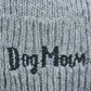 Nahaufnahme von dem gestickten „Dog Mom“-Schriftzug auf Wollmütze, Strickmütze und Beanie-Mütze aus Schurwolle, Hellgrau.